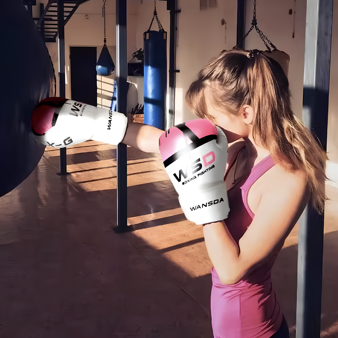 A woman training in a gym with pink and white boxing gloves, suitable for fitness and boxing training.